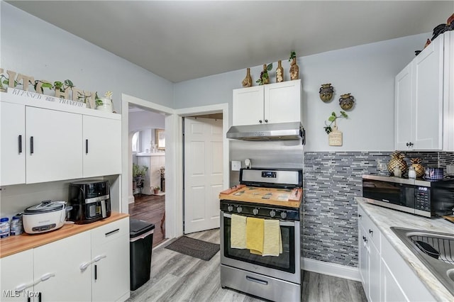 kitchen featuring appliances with stainless steel finishes, white cabinets, and light hardwood / wood-style flooring