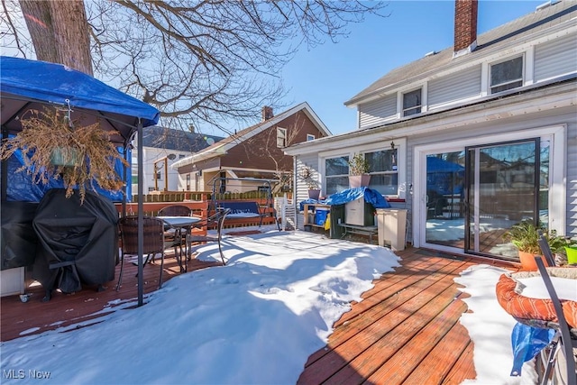 snow covered deck featuring a grill