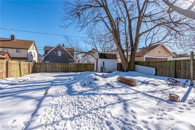 yard covered in snow with a storage unit