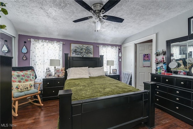 bedroom featuring ceiling fan, lofted ceiling, dark hardwood / wood-style flooring, and a textured ceiling