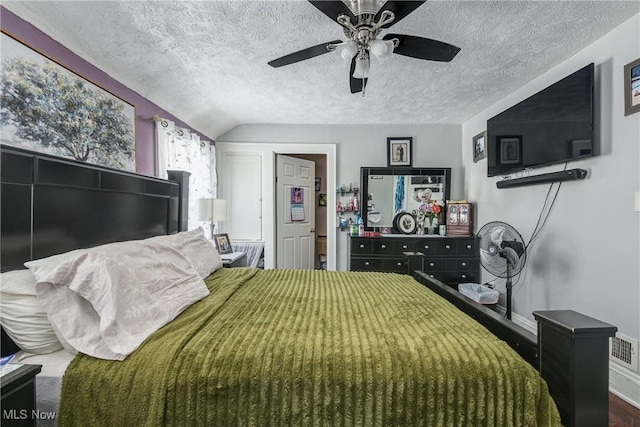 bedroom with lofted ceiling, a textured ceiling, wood-type flooring, and ceiling fan