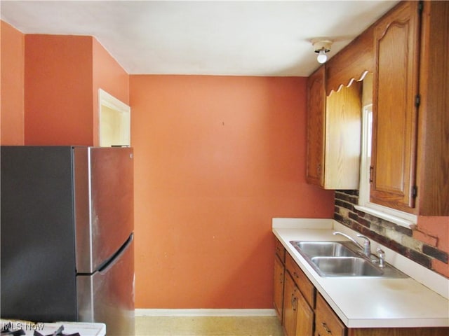 kitchen with sink, stainless steel refrigerator, and decorative backsplash