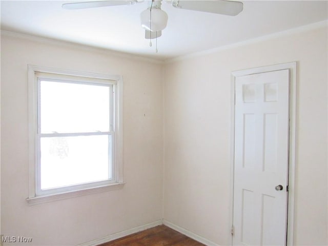 unfurnished room with ornamental molding, a wealth of natural light, and dark hardwood / wood-style flooring