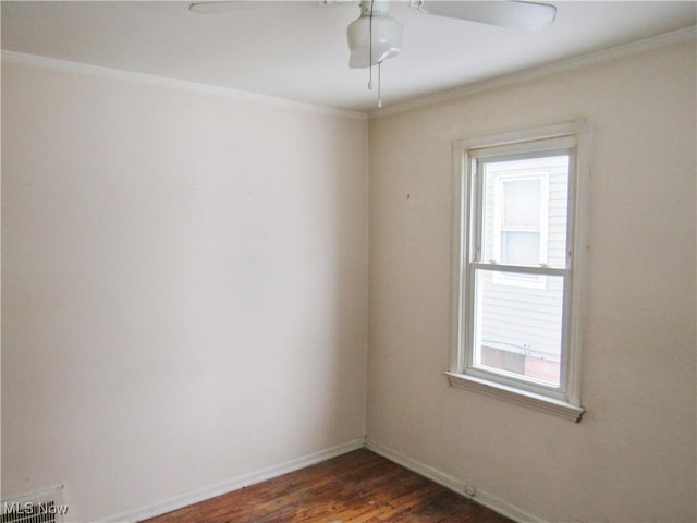 empty room with dark hardwood / wood-style flooring, ornamental molding, and ceiling fan