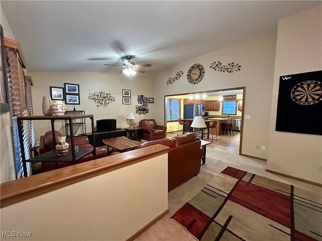 living room featuring lofted ceiling, light carpet, and ceiling fan