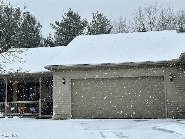 view of snow covered exterior featuring a garage