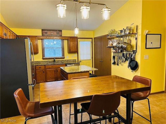 kitchen featuring sink, vaulted ceiling, hanging light fixtures, appliances with stainless steel finishes, and a kitchen island