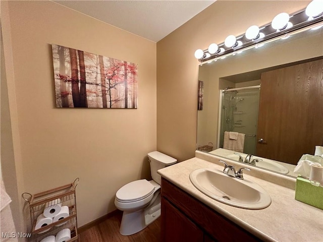 bathroom with walk in shower, vanity, toilet, and hardwood / wood-style flooring