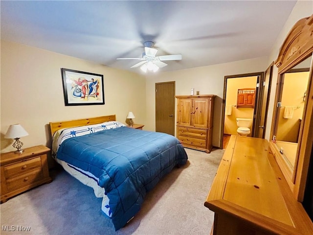 bedroom featuring ceiling fan, connected bathroom, and light carpet