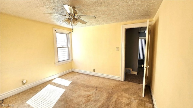 unfurnished room with ceiling fan, light carpet, and a textured ceiling