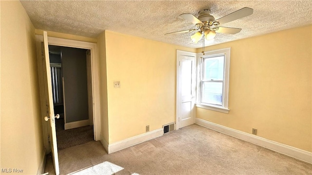 unfurnished room featuring light carpet, a textured ceiling, and ceiling fan