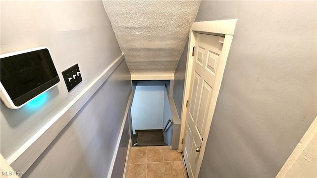 stairway featuring a textured ceiling