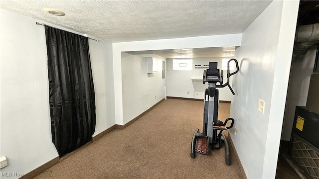 workout room featuring carpet floors and a textured ceiling