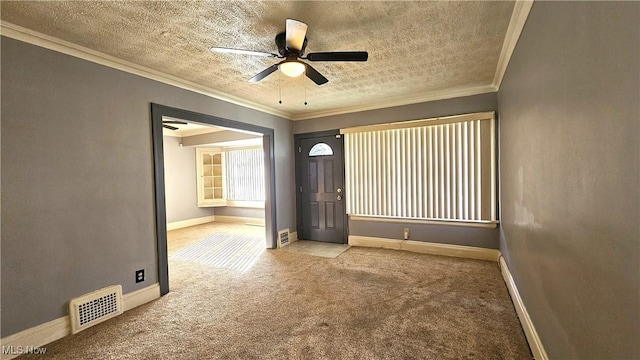 carpeted empty room featuring ornamental molding, a textured ceiling, and ceiling fan