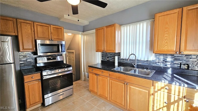 kitchen with light tile patterned flooring, sink, backsplash, ceiling fan, and stainless steel appliances