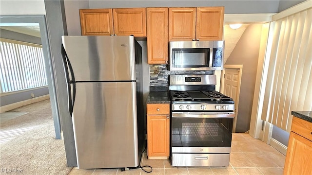 kitchen with light colored carpet, stainless steel appliances, and decorative backsplash