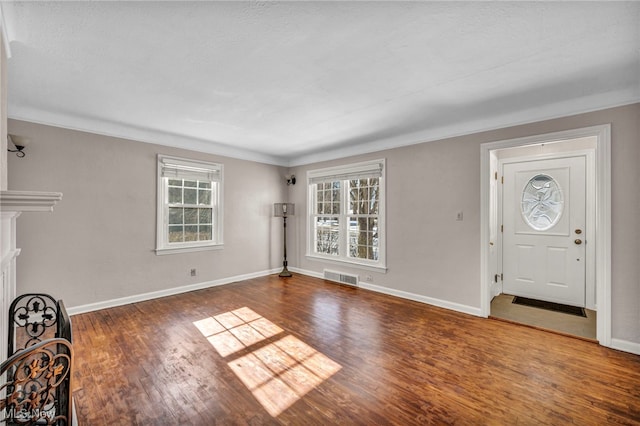 entryway featuring crown molding and dark hardwood / wood-style floors