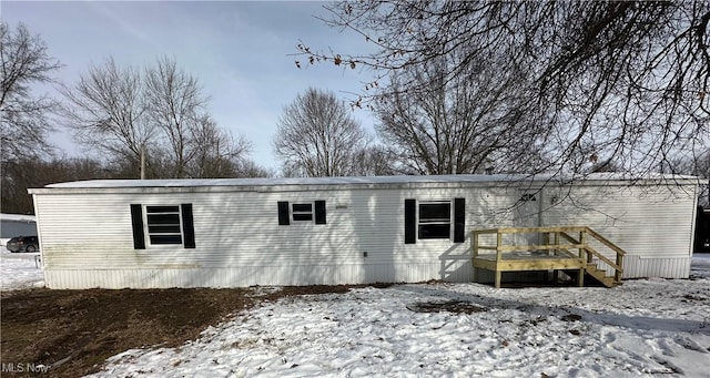 snow covered property with a wooden deck