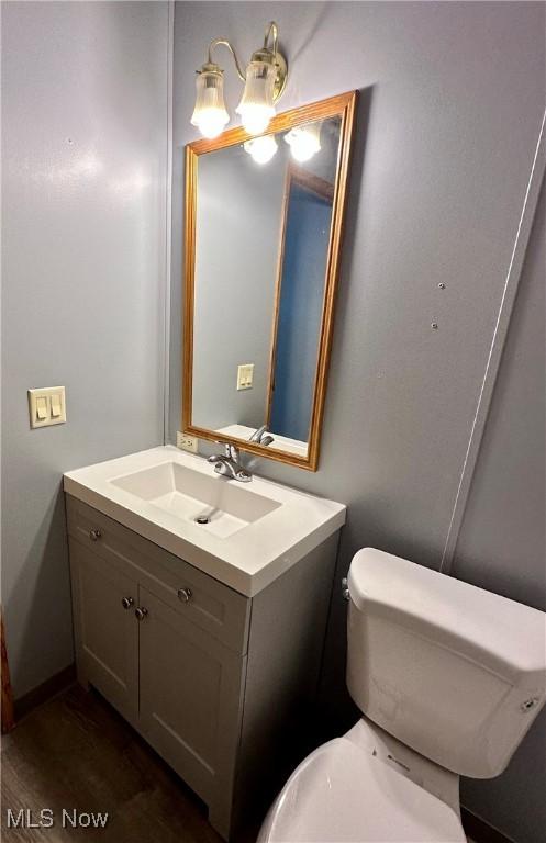 bathroom featuring vanity, wood-type flooring, and toilet