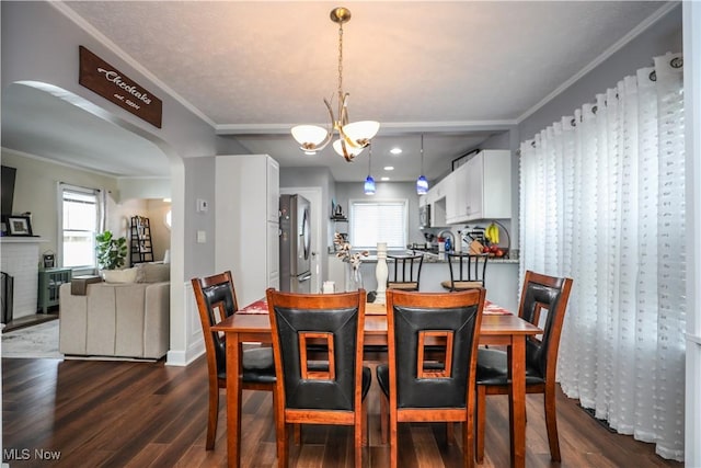 dining room featuring dark hardwood / wood-style flooring, crown molding, and an inviting chandelier