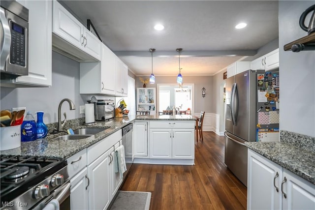 kitchen featuring white cabinetry, appliances with stainless steel finishes, sink, and pendant lighting