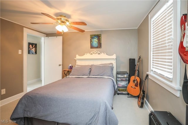 carpeted bedroom with crown molding and ceiling fan