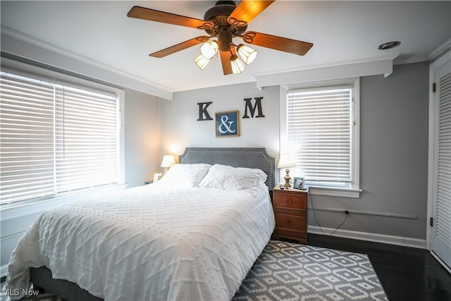 bedroom featuring crown molding, dark wood-type flooring, and ceiling fan