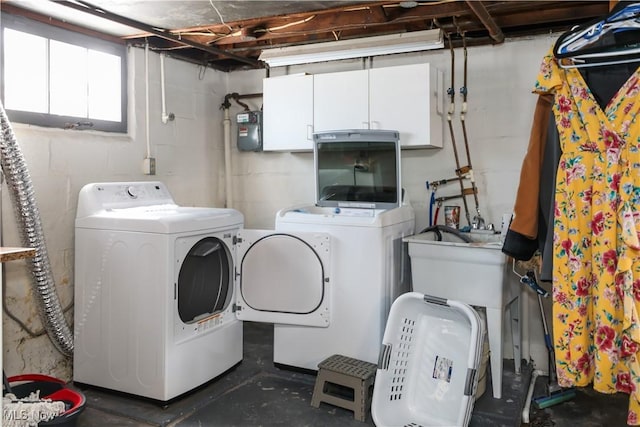 clothes washing area featuring cabinets and washing machine and clothes dryer