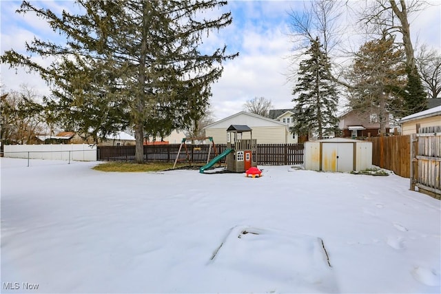 snow covered playground with a storage shed