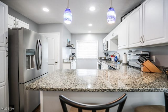 kitchen with a kitchen bar, kitchen peninsula, and appliances with stainless steel finishes