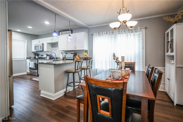 dining area featuring ornamental molding, dark hardwood / wood-style floors, sink, and a chandelier