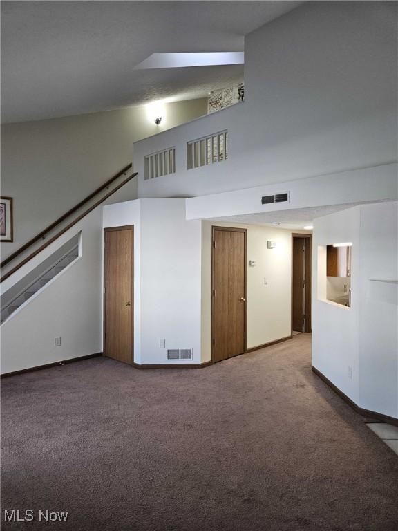 carpeted spare room with a high ceiling