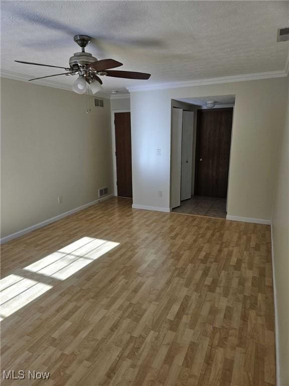 unfurnished room featuring hardwood / wood-style flooring, ornamental molding, and a textured ceiling