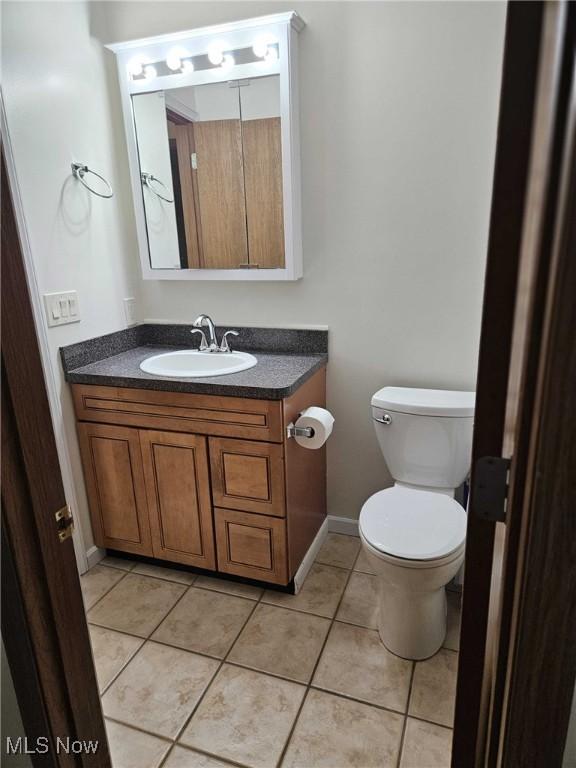 bathroom featuring vanity, tile patterned floors, and toilet