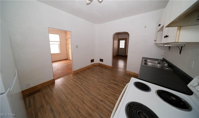 kitchen with sink, white range with electric cooktop, dark hardwood / wood-style floors, white cabinets, and exhaust hood