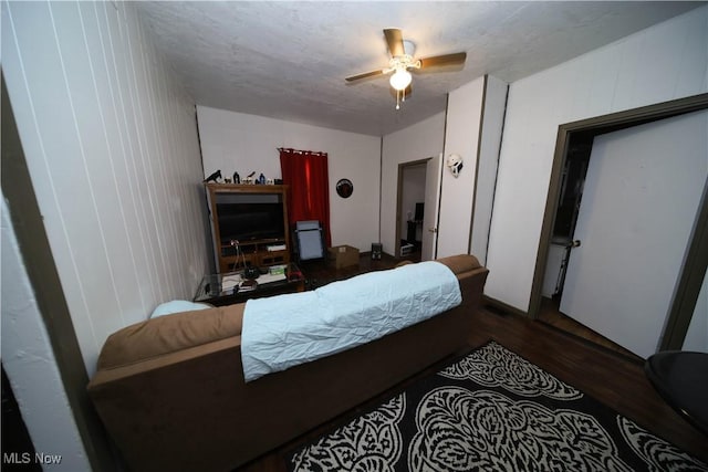 bedroom featuring ceiling fan, dark hardwood / wood-style floors, and a textured ceiling