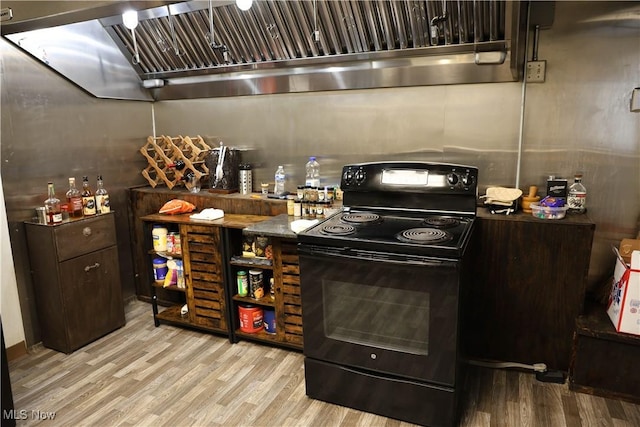 kitchen with black range with electric stovetop, light hardwood / wood-style floors, and dark brown cabinets