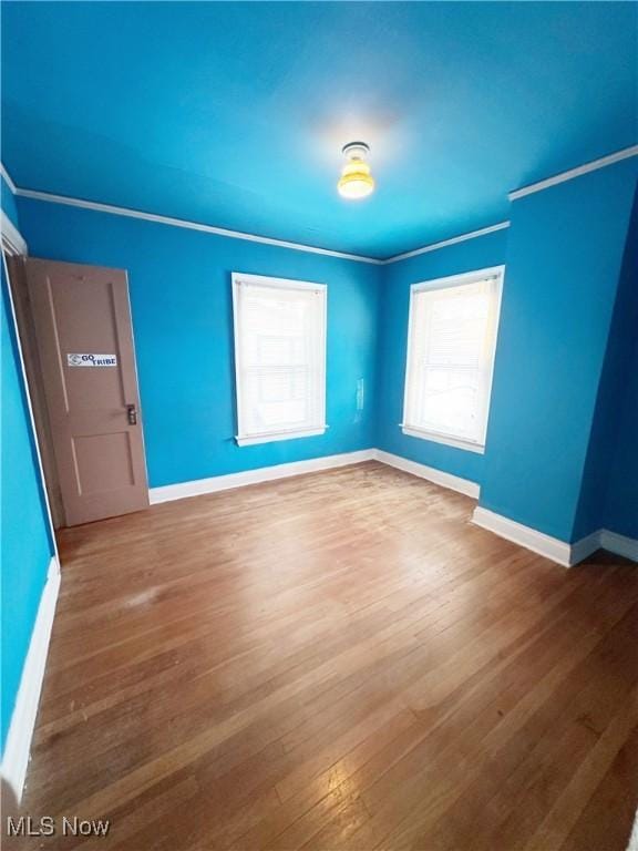 spare room featuring ornamental molding and hardwood / wood-style floors