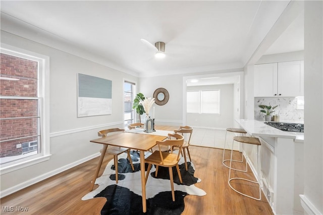 dining space featuring crown molding, a wealth of natural light, and light wood-type flooring