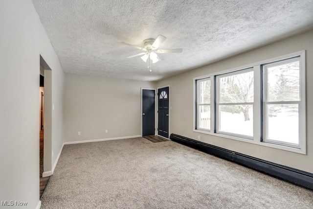 unfurnished room with baseboard heating, ceiling fan, carpet flooring, and a textured ceiling