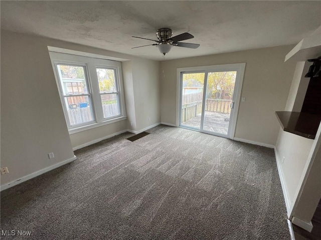 unfurnished living room featuring ceiling fan and dark carpet