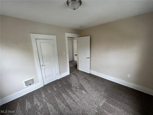 unfurnished bedroom featuring dark colored carpet