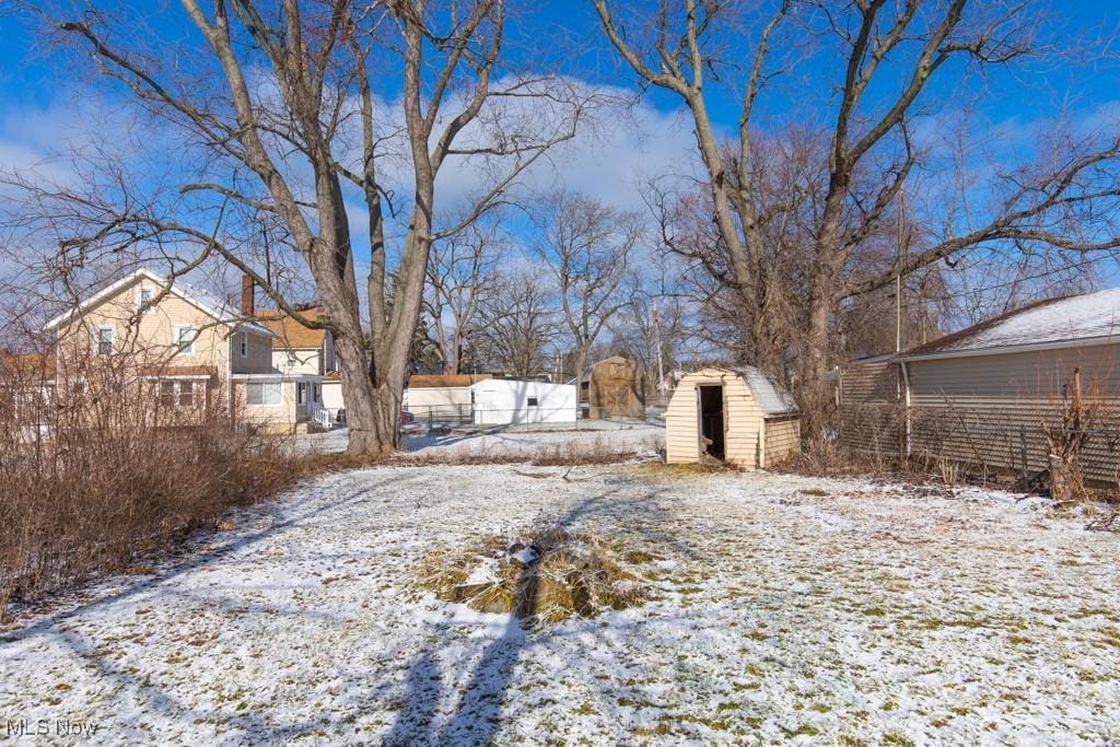 yard layered in snow featuring a storage shed