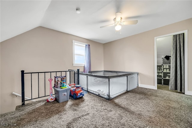 interior space with a ceiling fan, carpet flooring, vaulted ceiling, and baseboards