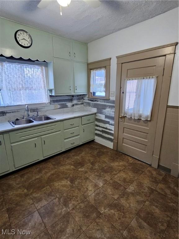 kitchen featuring sink, a wealth of natural light, a textured ceiling, and green cabinets