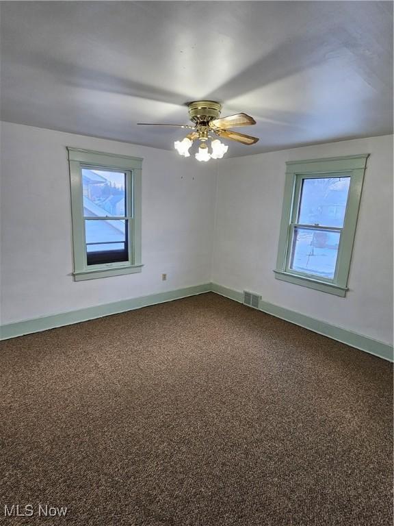 spare room featuring ceiling fan and carpet