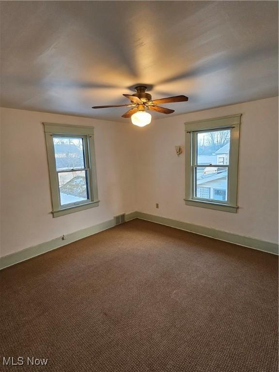 empty room featuring carpet floors and ceiling fan