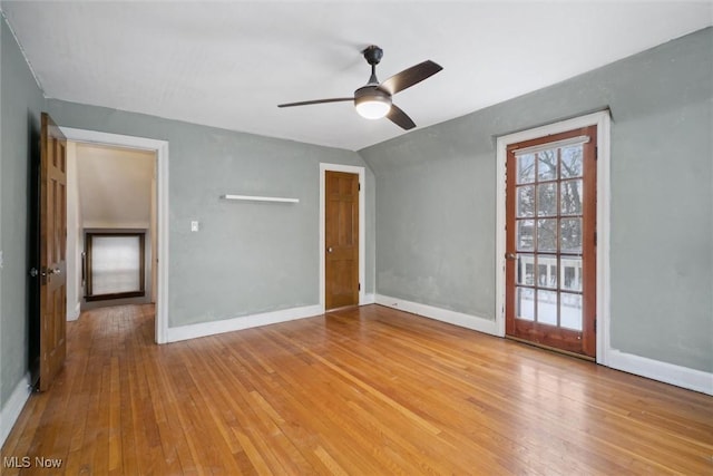 empty room featuring lofted ceiling, ceiling fan, and light wood-type flooring