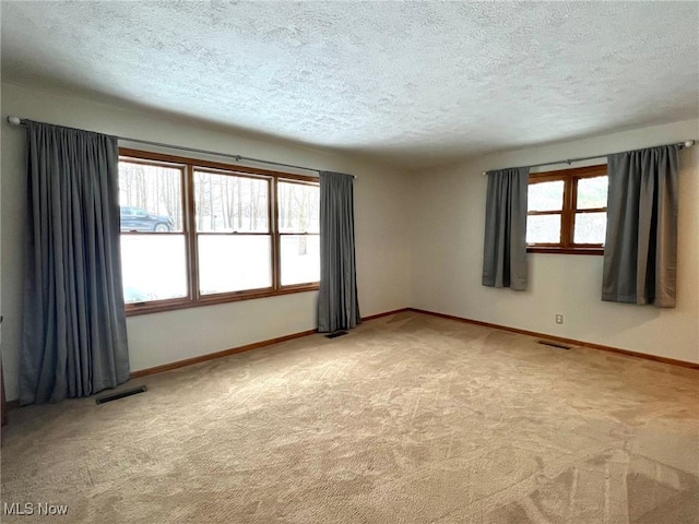 carpeted empty room featuring a textured ceiling