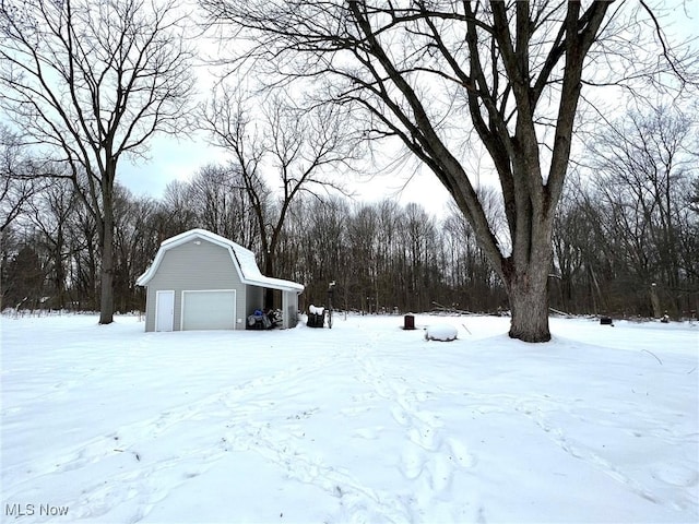 yard layered in snow featuring a garage